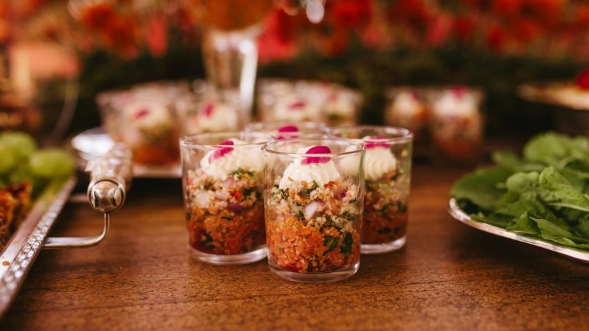 A vibrant display of gourmet appetizers in cups at a wedding reception.